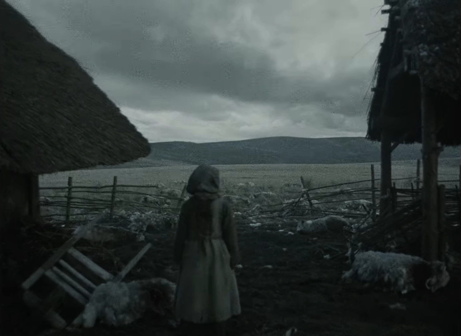 A hooded figure facing the open moor